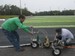 Corey King, left, and Conner Whitener, right, uses an air driven sewing machine to stitch together sections of AstroTurf during the installation of the new playing surface at University of West Football facility Friday morning Jan. 8, 2016.